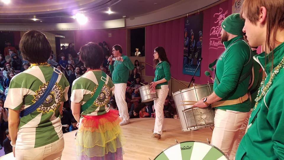 Drummers on Stage wearing green shirts